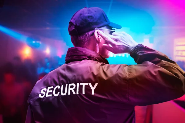 Male Security Officer Wearing Cap Trying Listen Something Earphones Night — Stock Photo, Image