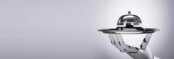 グレーを背景にしたシルバープレート上のロボットハンドホルダー — ストック写真