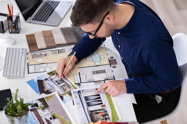 Side View Of Real Estate Designer Working On Computer In Office