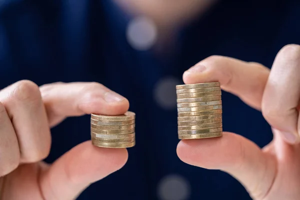 Man Holding Two Coin Stacks Compare — Stock Photo, Image