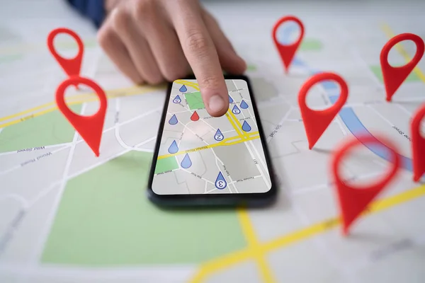 在手机上使用带有红色位置标记的地图的人 — 图库照片