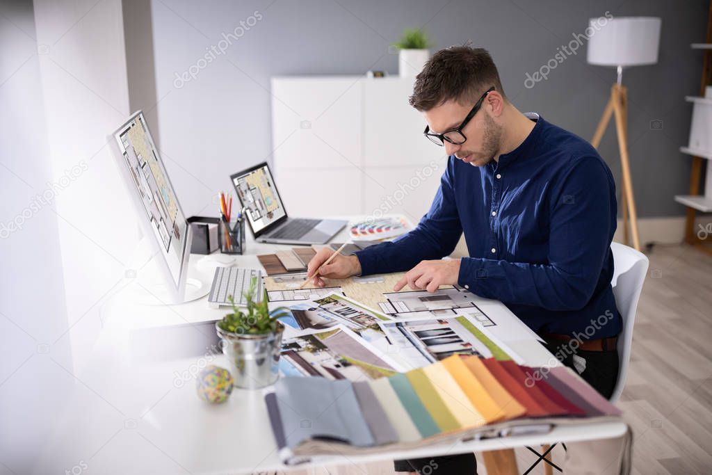 Side View Of Real Estate Designer Working On Computer In Office