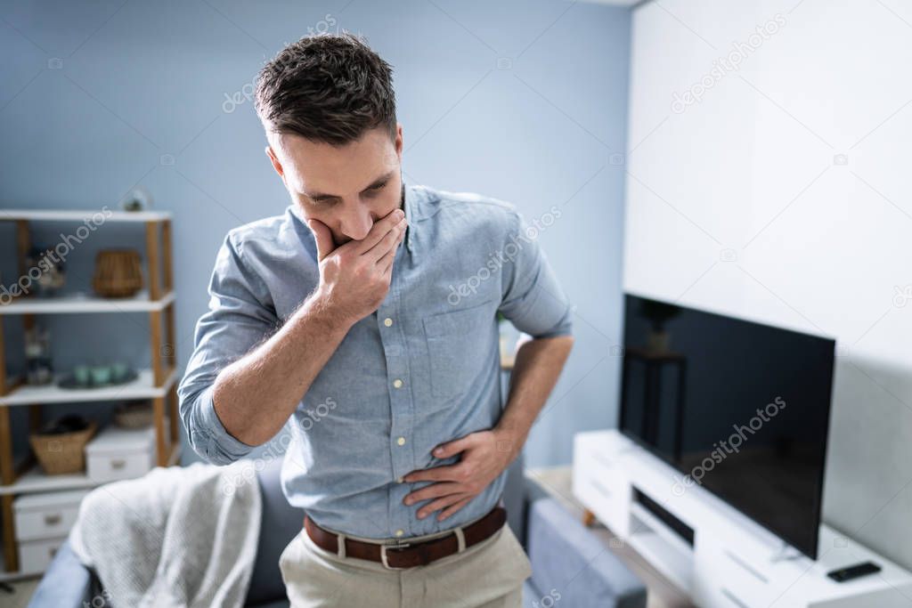 Young Man Suffering From Nausea At Home
