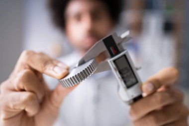 Bir erkek takımları boyutu gri arka plan üzerinde dijital elektronik Vernier kumpas ile ölçme Close-up
