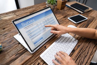 Ofisteki dizüstü bilgisayarda iş kadınının online araştırma yaparken çekilmiş resmi.