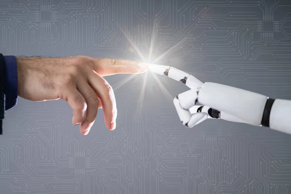 灰色の背景の人間の指に触れるロボット — ストック写真