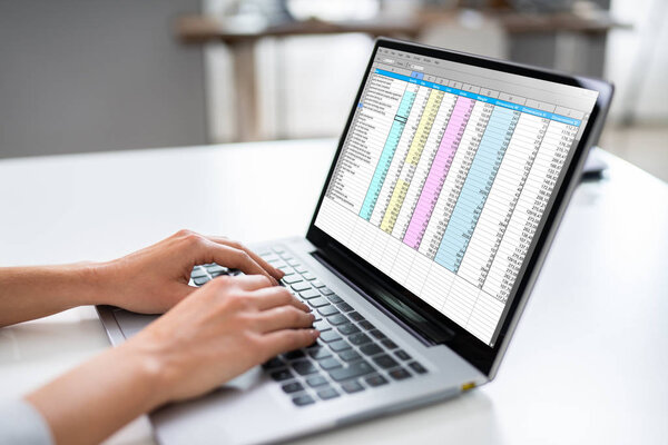 Close-up Of A Person's Hand Typing On Laptop Over Wooden Desk