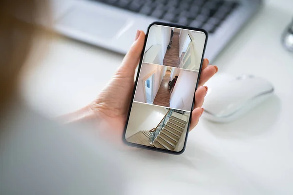 Mano Persona Sosteniendo Teléfono Inteligente Monitoreando Video Contra Mesa Madera —  Fotos de Stock