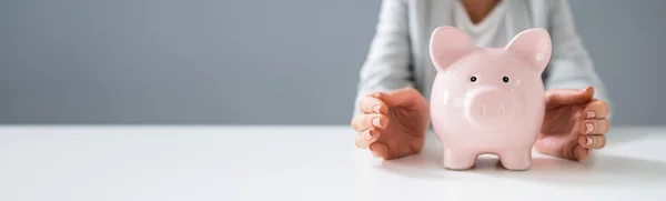 Primer Plano Una Mano Humana Protegiendo Pink Piggy Bank Escritorio — Foto de Stock