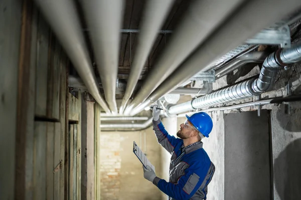 Arbeiter Inspiziert Wasserleitungen Auf Undichte Stellen Keller — Stockfoto