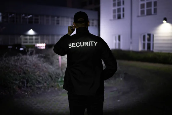 Bezpečnostní Stráž Kráčející Obvodu Budovy Baterkou Noci — Stock fotografie