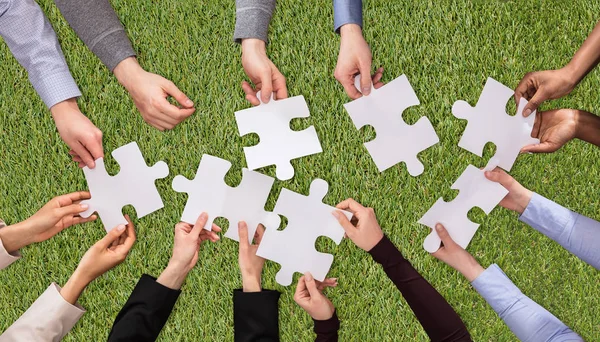 Overhead View People Hands Joining White Jigsaw Puzzles Green Grass — Stock Photo, Image