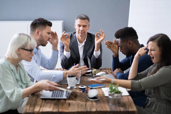 Geschäftsmann Meditiert Während Seine Kollegen Büro Gespräche Führen — Stockfoto