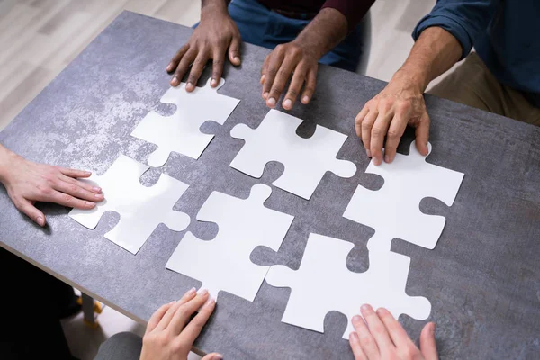 Hochwinkel Ansicht Von Geschäftsleuten Hände Beim Lösen Puzzle — Stockfoto