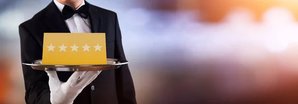 Portrait Of African Waiter Holding Plate With Star Rating