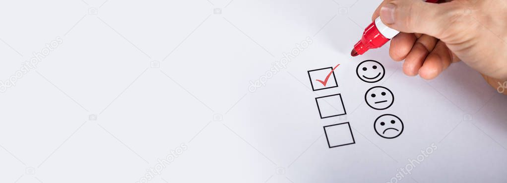 Satisfied Customer Putting Check Mark On Quality Service Survey Checklist Next To Drawn Happy Face