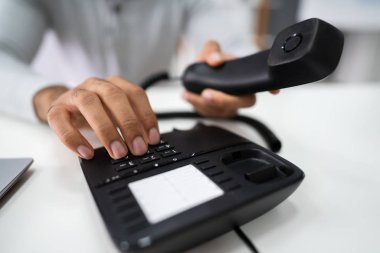 Bir telefon görüşmesi yapmak için iş adamı telefon numarasını çeviriyor