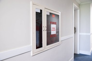 Yangın hortumu ve yangın söndürücü otel koridorunda.