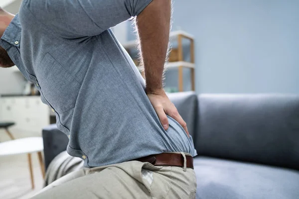 Volwassen Man Met Rugpijn Terwijl Zitten Bank — Stockfoto