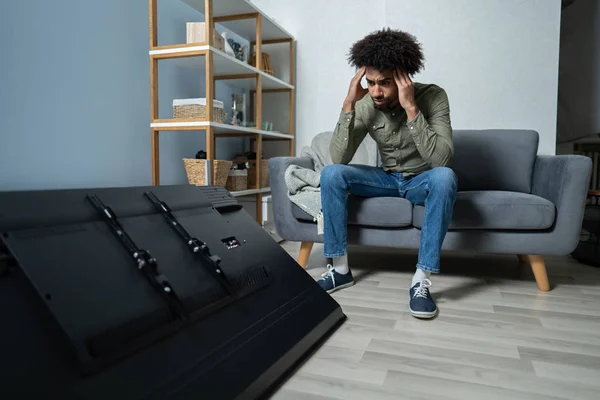 Homme Assis Sur Canapé Devant Télévision Tombée Avec Écran Cassé — Photo