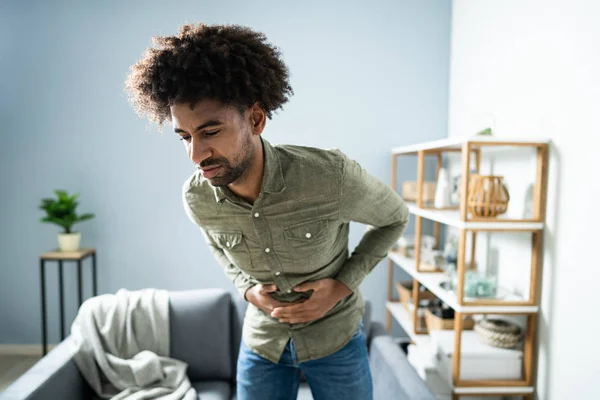 Midsection Homem Com Dor Estômago Perto Sofá Casa — Fotografia de Stock