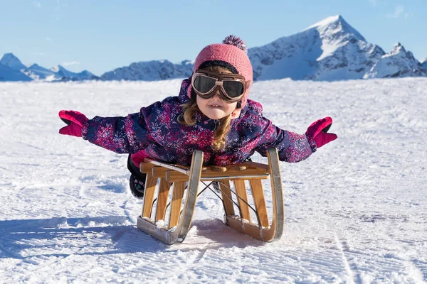 ラアックスで雪の中でそりと陽気な女の子のスライド — ストック写真