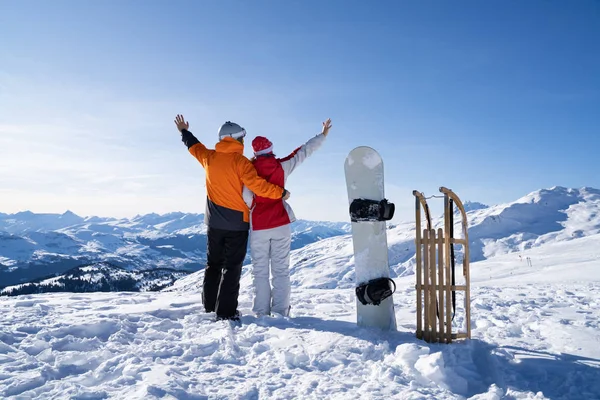 站在雪板附近的年轻夫妇和在雪中的木制誓言 — 图库照片