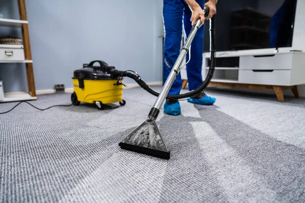 Foto Janitor Pulizia Tappeto Con Aspirapolvere — Foto Stock