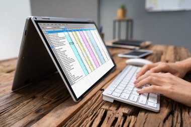 Bir iş kadını'nın el laptop Office elektronik tablo inceleyerek Close-up