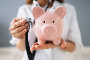 Genç Kadın Doktor Klinikte Kumbarayı Tutarken Orta Bölüm