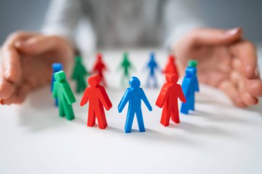 Beyaz Masa Üzerinde Daire Oluşturan Çok Renkli Piyonları Koruyan Bir Kişinin Elinin Yakın Çekim