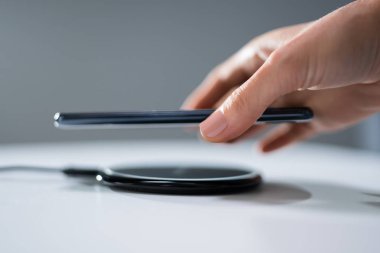 Akıllı Telefon Şarj Eden Kadın Evde Kablosuz Şarj Pedi Kullanıyor