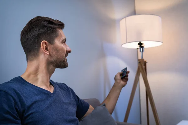 Person Controlling Smart Light Remote Control — Stock Photo, Image