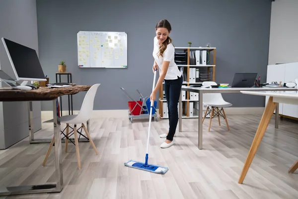 Full Length Female Janitor Mopping Floor Office — Stockfoto