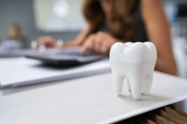 計算機でビルを計算する女の前で机の上に白い歯のクローズアップ — ストック写真