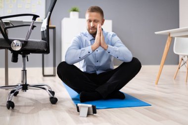 İşadamı Ofiste Akıllı Telefon Uygulaması Kullanarak Meditasyon Yapıyor