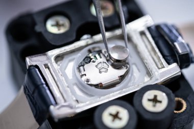 Pil üzerinde Gümüş Kol saati yerleştirerek cımbız Close-Up