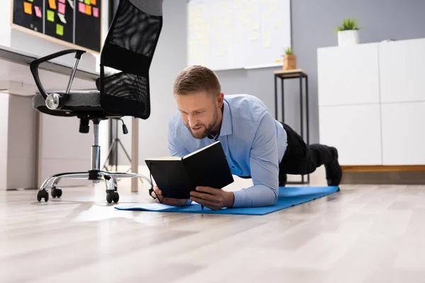 Businessman Reading Notes While Doing Plank Exercise Office — Stock Photo, Image