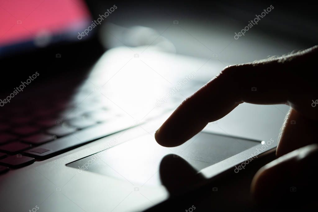 Close-up Of A Person's Hand Using Touchpad On Laptop