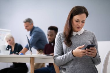 Toplantıda cep telefonu kullanan dikkati dağılmış iş kadını