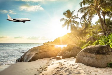 Airplane Is Flying In Cloudy Sky Over Island And Sea In Summer At Seychelles clipart