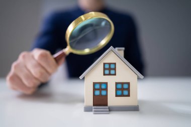 Ev modeli Büyüteç aracılığıyla bakarak bir işadamının'ın el Close-Up
