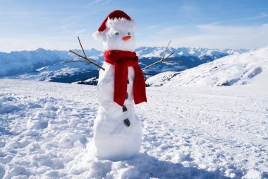 Karlı arazide şapkası ve atkısı olan tamamlanmamış bir kardan adamın düşük açılı görüntüsü