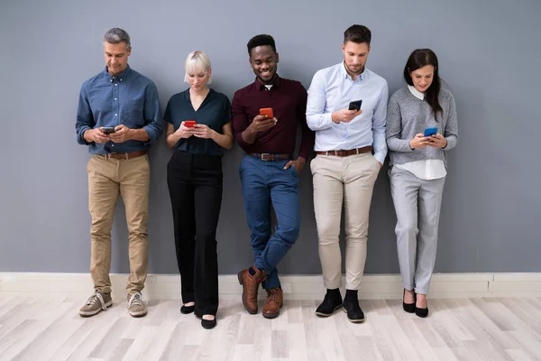 Fila Empresários Diversos Usando Telefones Escritório — Fotografia de Stock