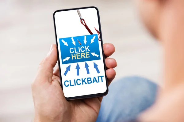 Personens Hand Håller Mobiltelefon Med Clickbait — Stockfoto