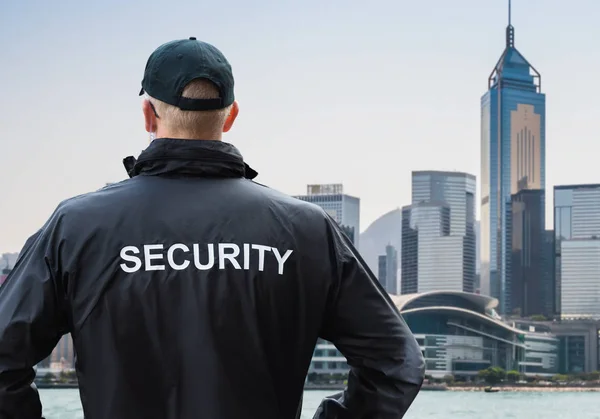 Vista Trasera Del Guardia Seguridad Masculino Mirando Horizonte Ciudad Distrito —  Fotos de Stock