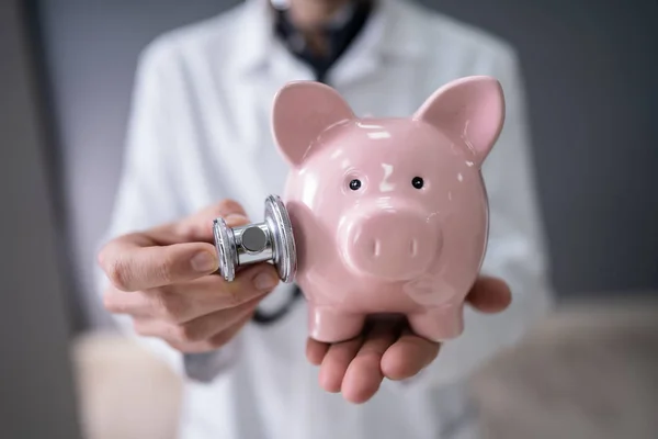 Beskuren Bild Manliga Läkare Undersöka Piggybank Med Stetoskop — Stockfoto