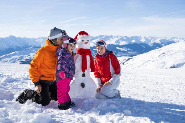 在冬季公园 一个快乐的家庭在雪人身边玩耍的肖像 — 图库照片