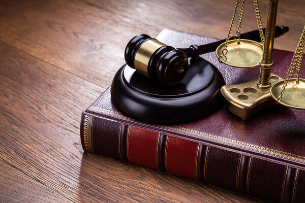 Wooden Gavel With Golden Scale Near Book On Table
