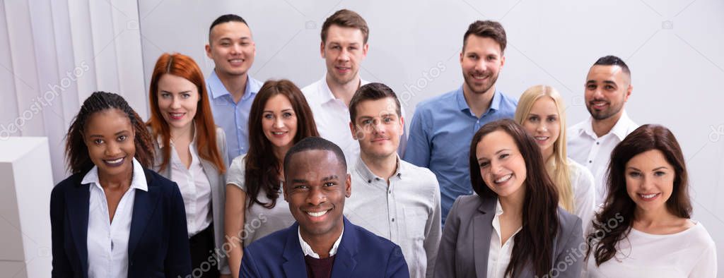 Group Of Young Successful Multi-ethnic Businesspeople Standing In Office Looking At Camera